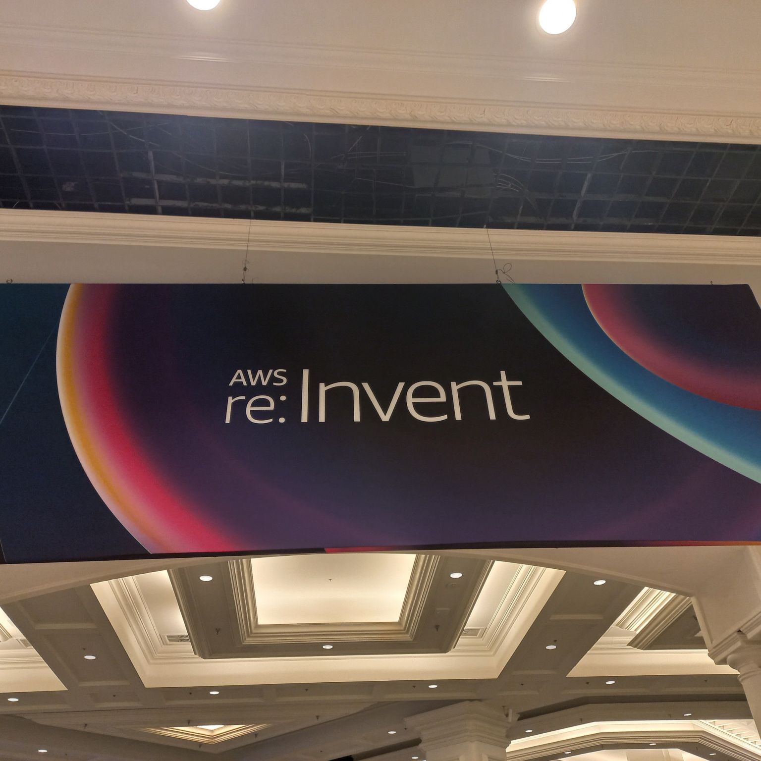 Banner handing from a ceiling reading "AWS re:Invent"