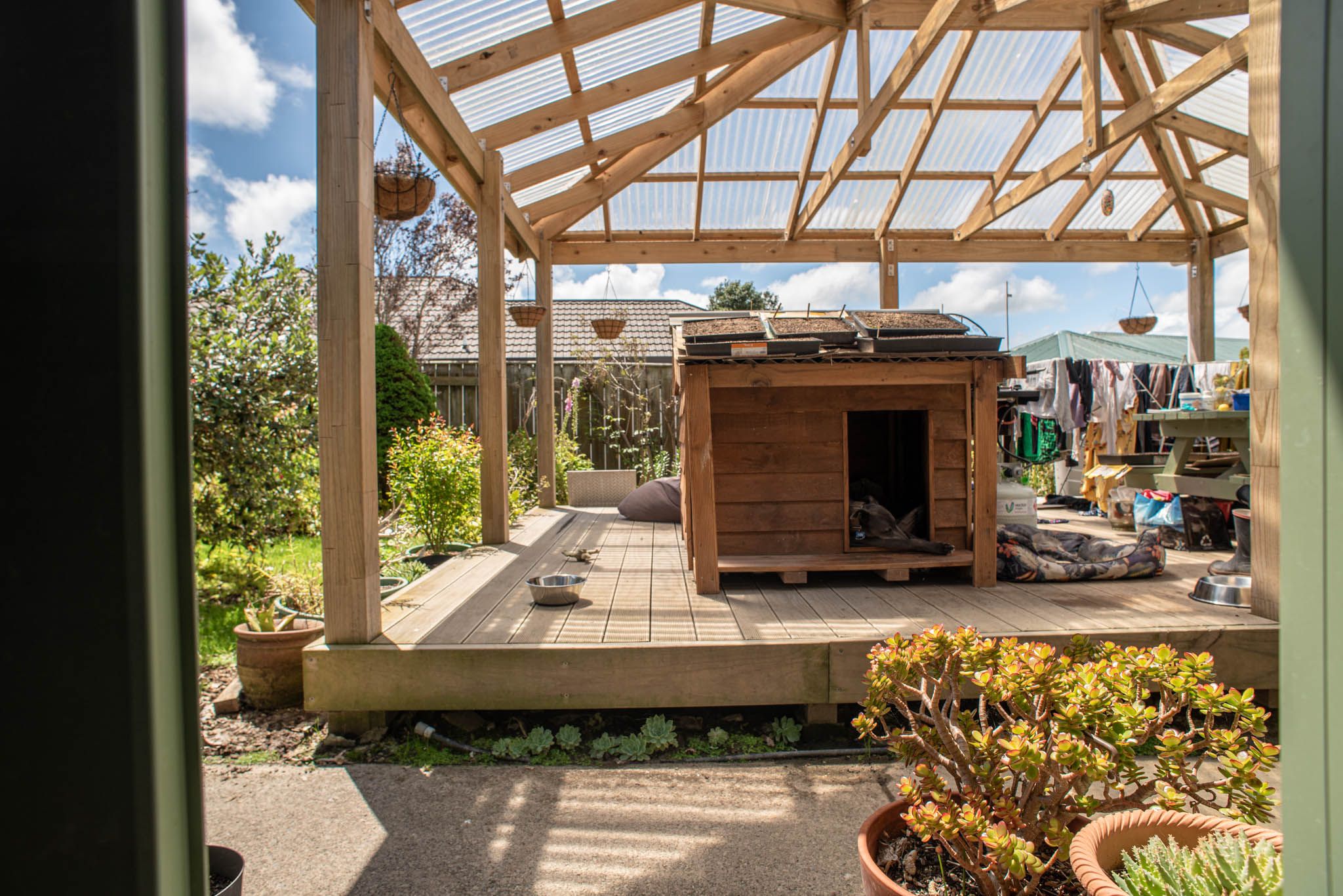 Gazebo in daylight with a dog inside a doghouse